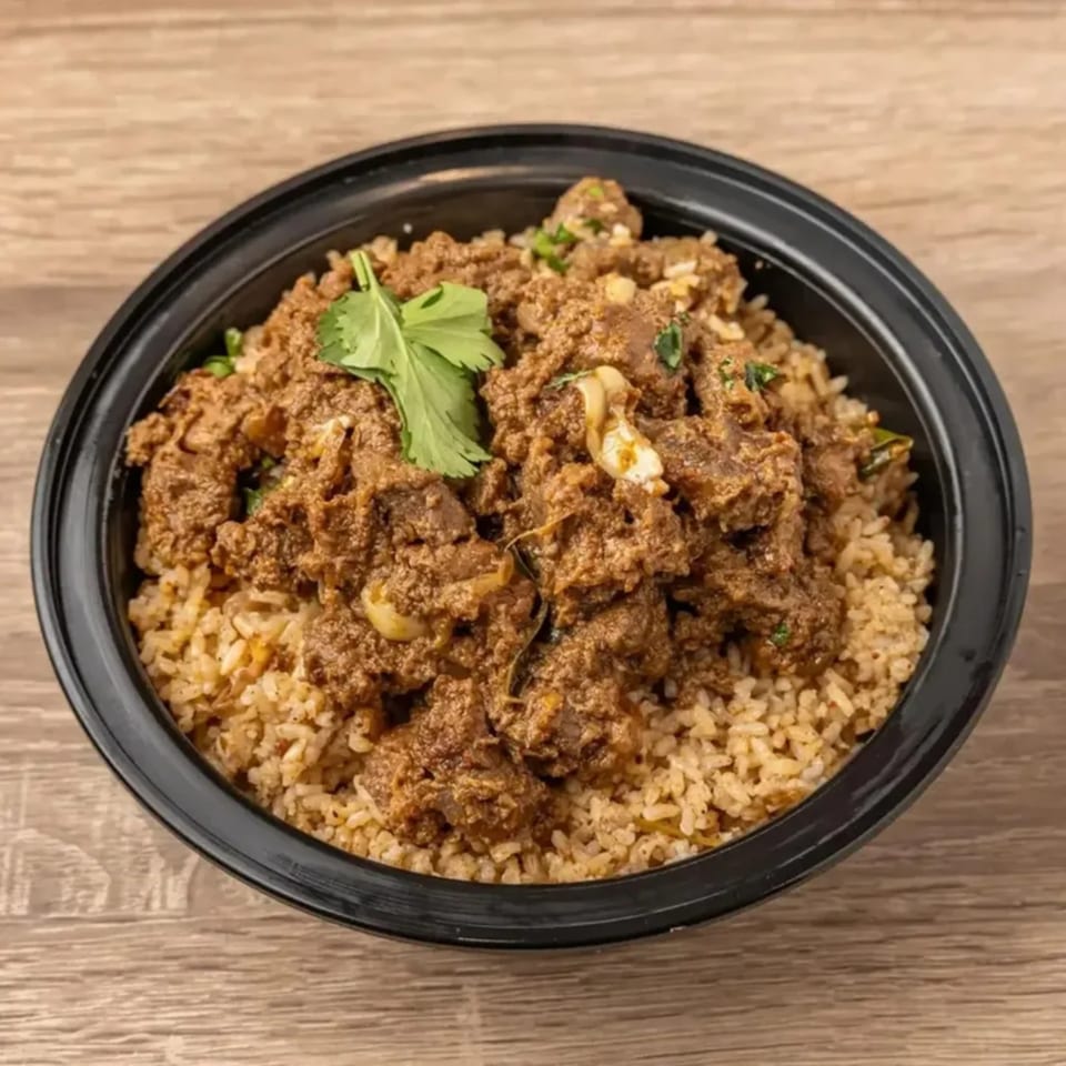 Kolapasi Indian Canteen's flavorful Indian mutton biryani with rice, garnished with fresh cilantro.
